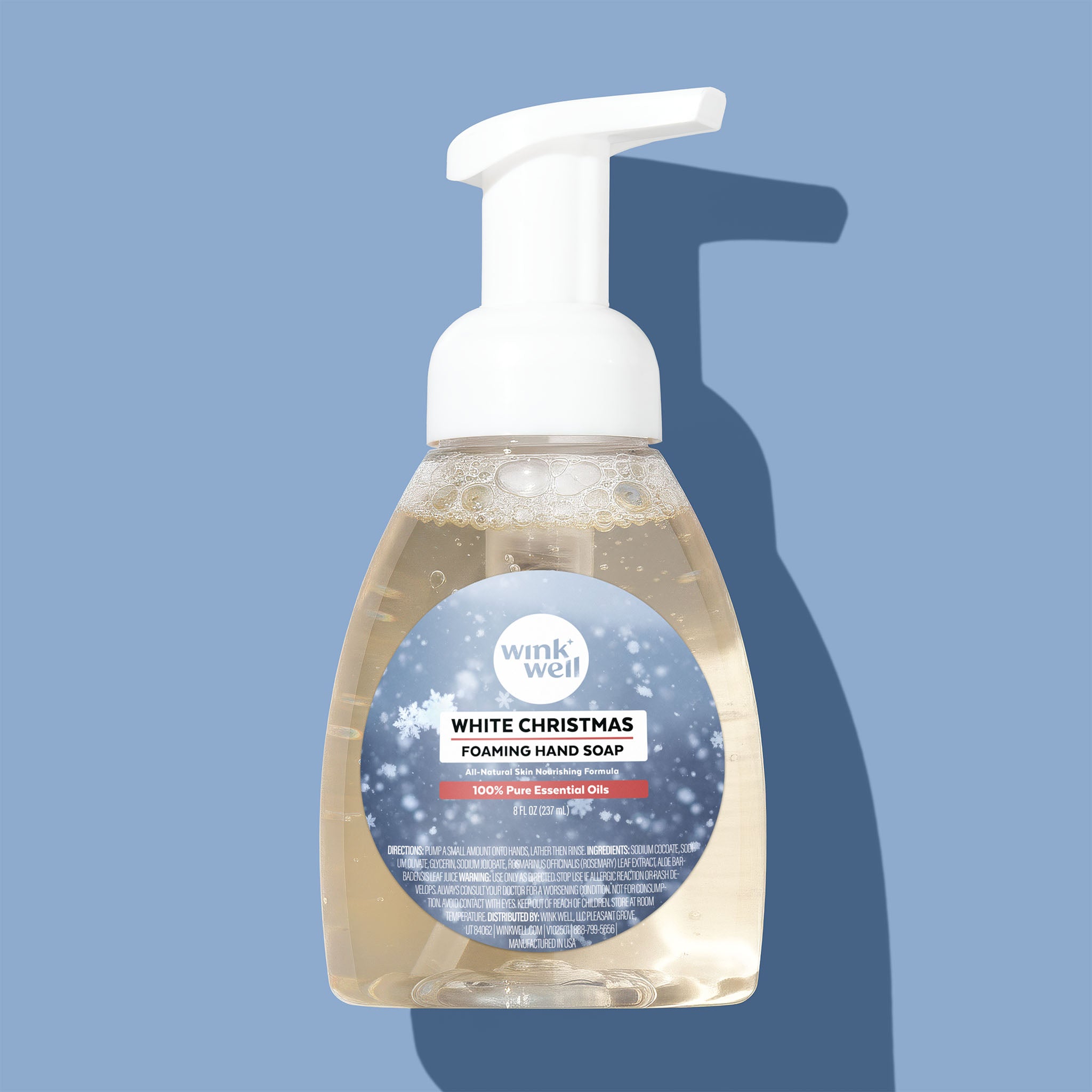 Foaming hand soap bottle with a blue label on a light blue background