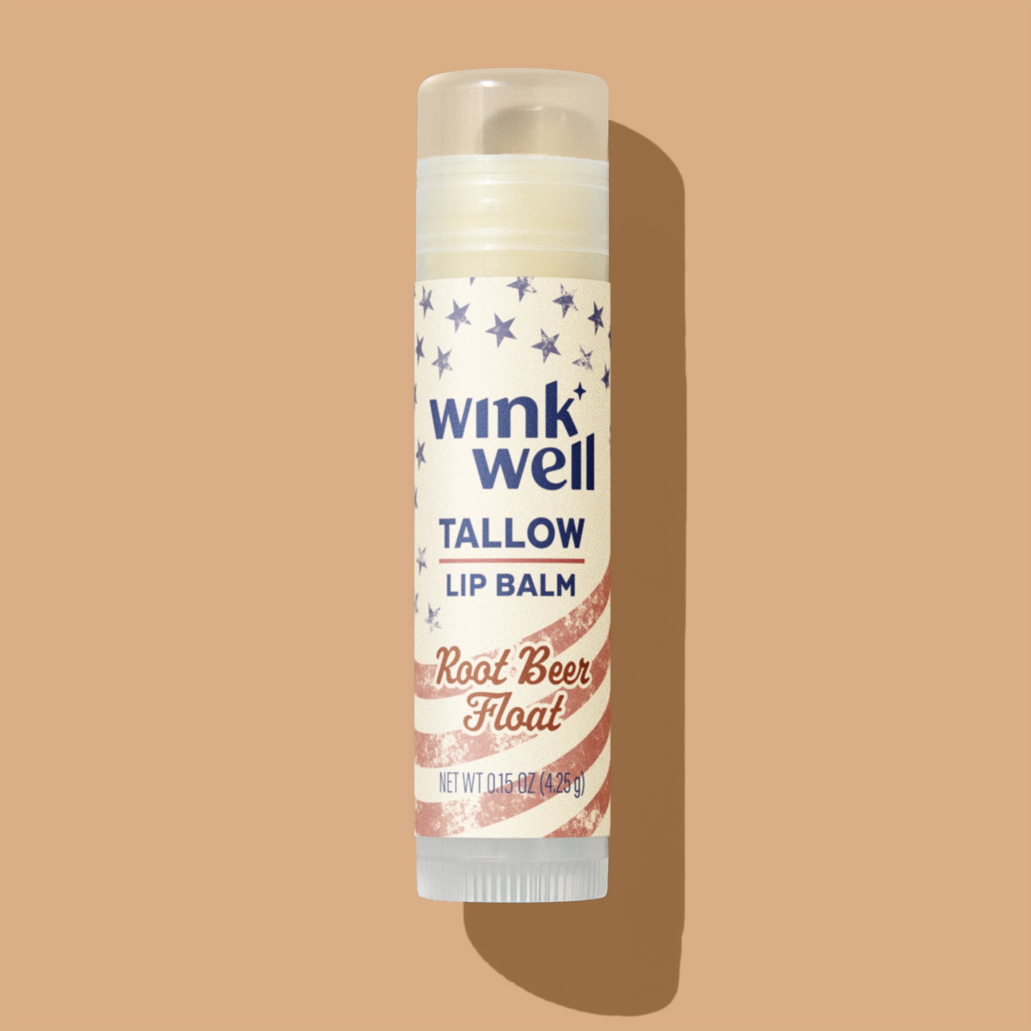 Wink Well Tallow Lip Balm in Root Beer Float flavor on a beige background, with a patriotic American stars and stripes design.