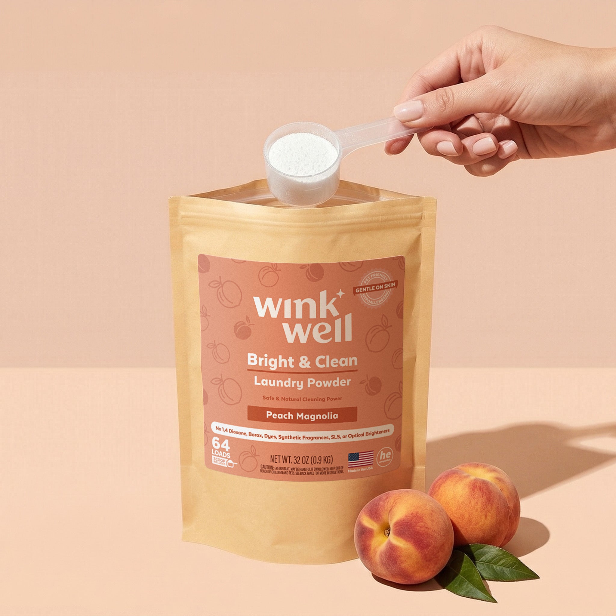 Wink Well laundry powder package with a hand holding a scoop and peaches on a beige background