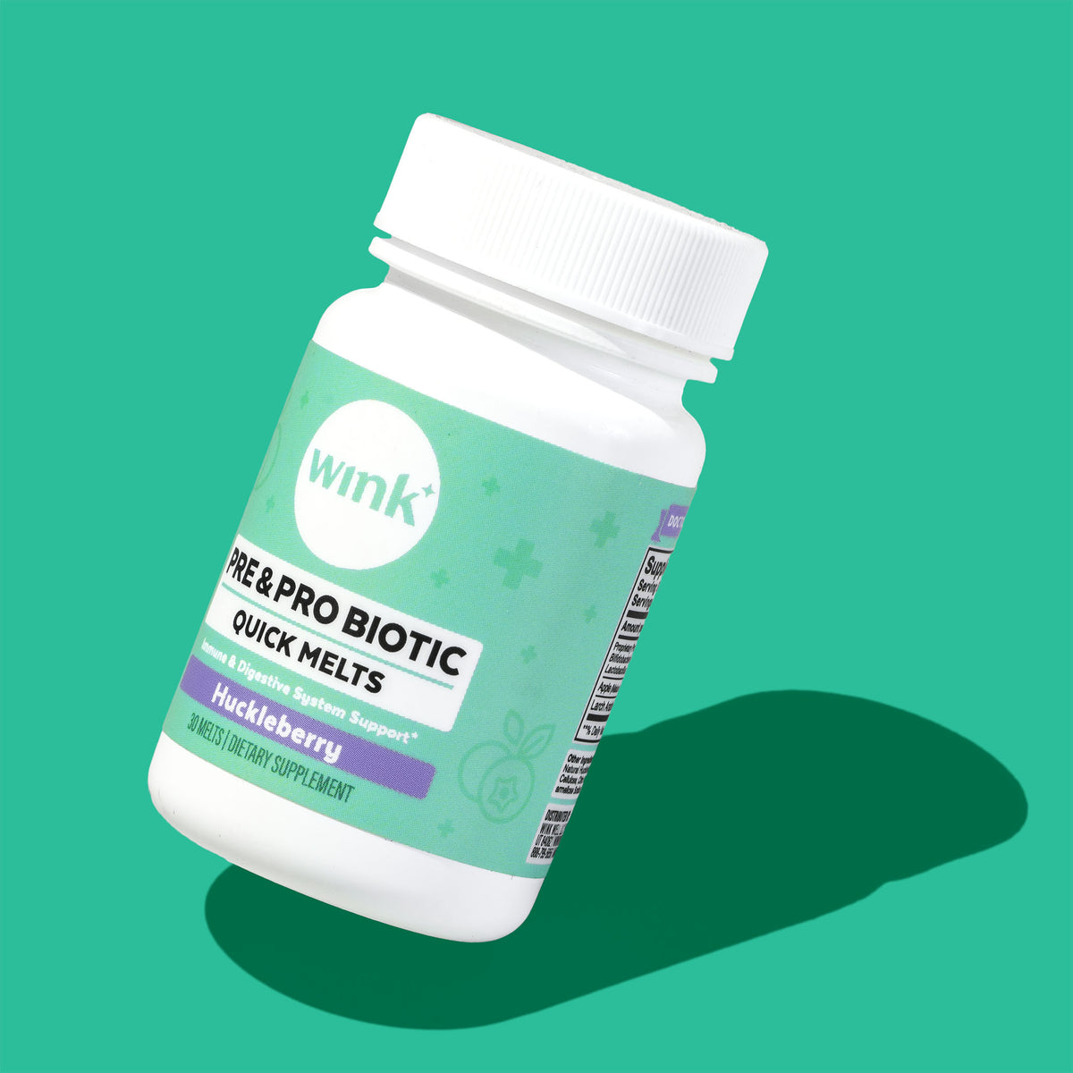 A white plastic bottle of Wink Pre & Pro Biotic Quick Melts dietary supplement, featuring a mint green and purple label, shown at an angle on a solid teal background with a dark green shadow.