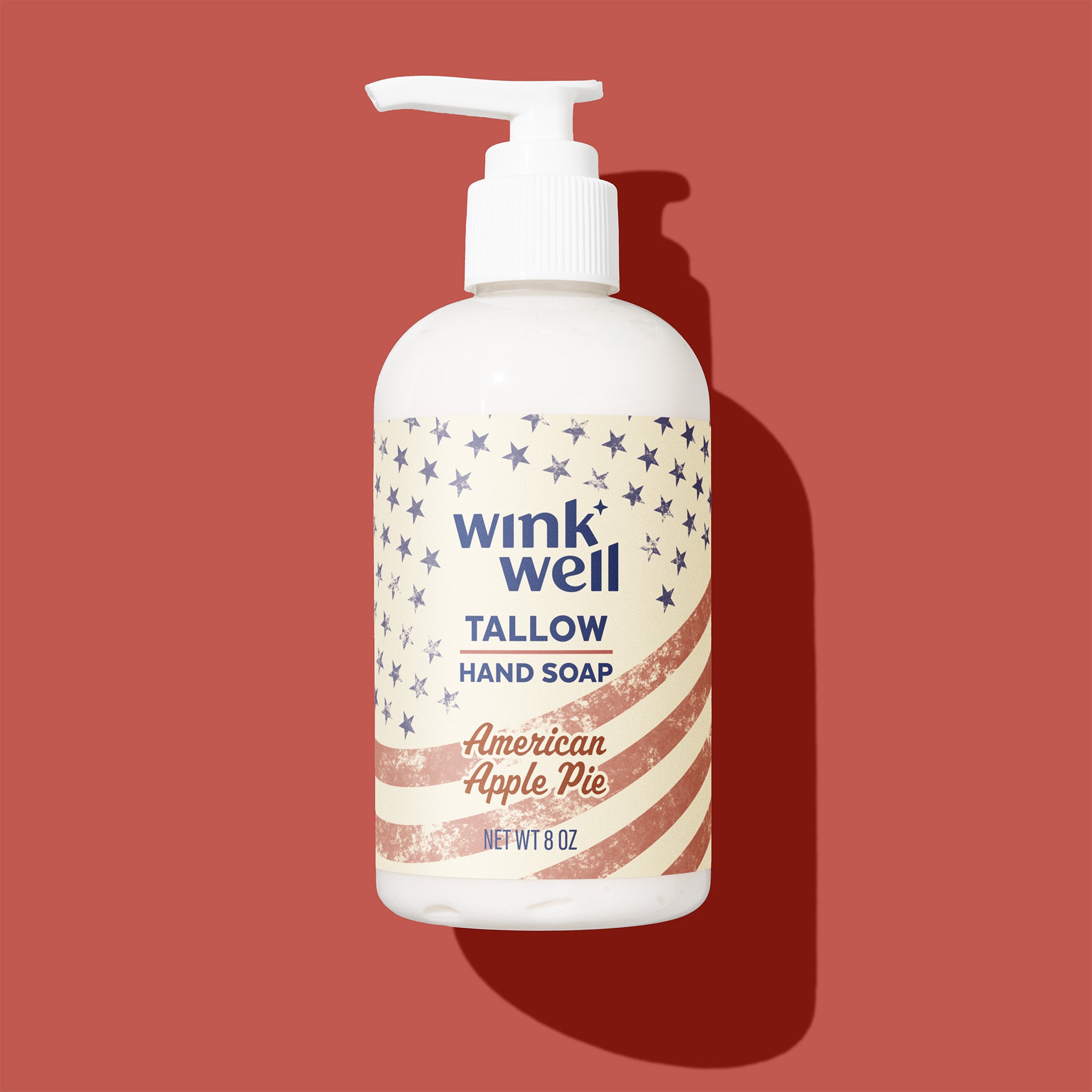 Wink Well tallow hand soap bottle with American Apple Pie scent on a red background, with a patriotic American stars and stripes design.