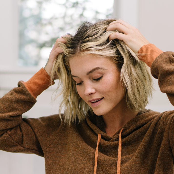 A woman running her fingers through her short hair